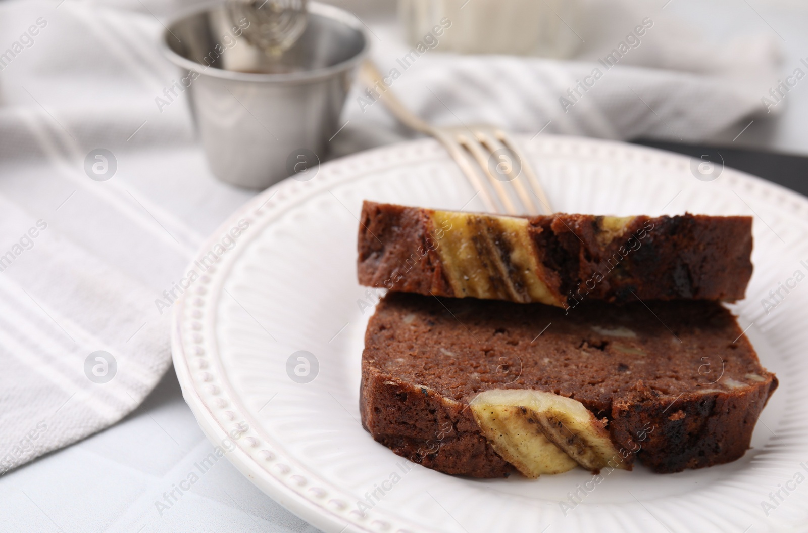 Photo of Slices of delicious banana bread served on table, closeup. Space for text