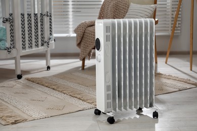 Photo of Modern portable electric heater in child room, space for text