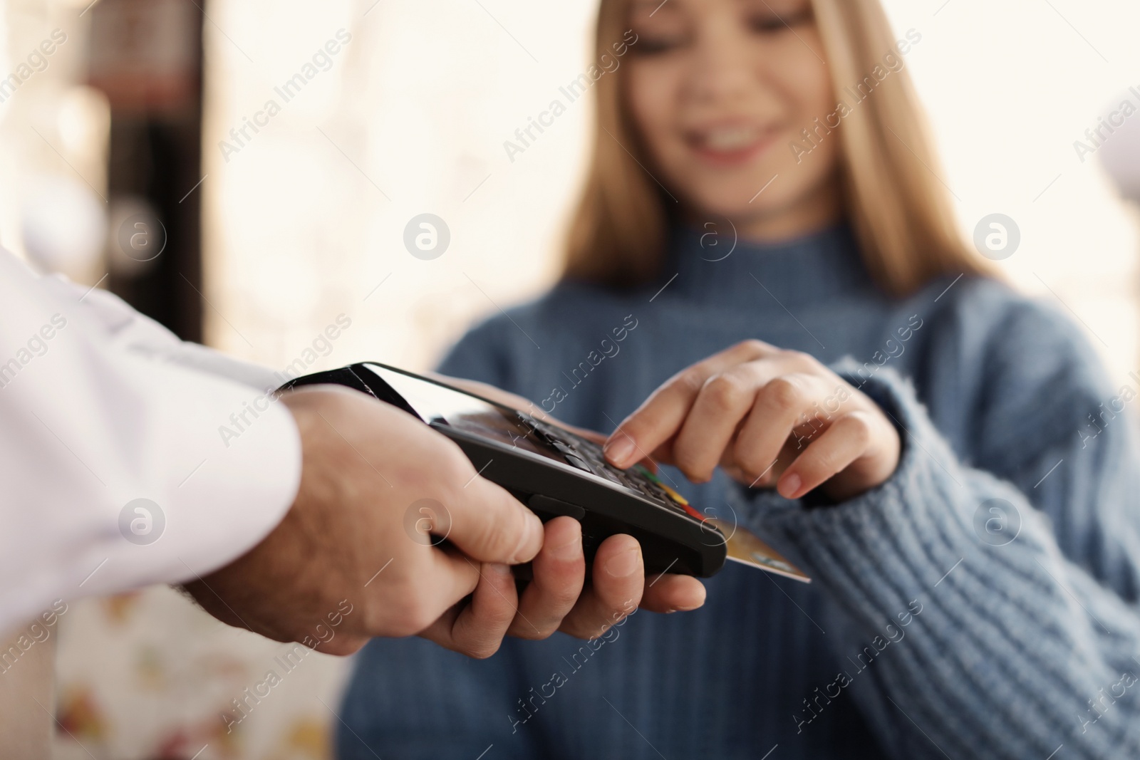 Photo of Woman with credit card using payment terminal at restaurant, closeup