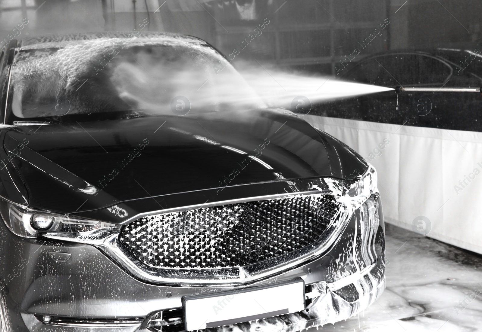 Photo of Cleaning automobile with high pressure water jet at car wash