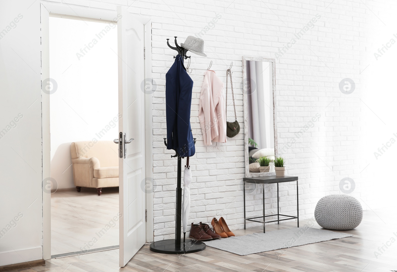 Photo of Stylish hallway interior with door and comfortable furniture