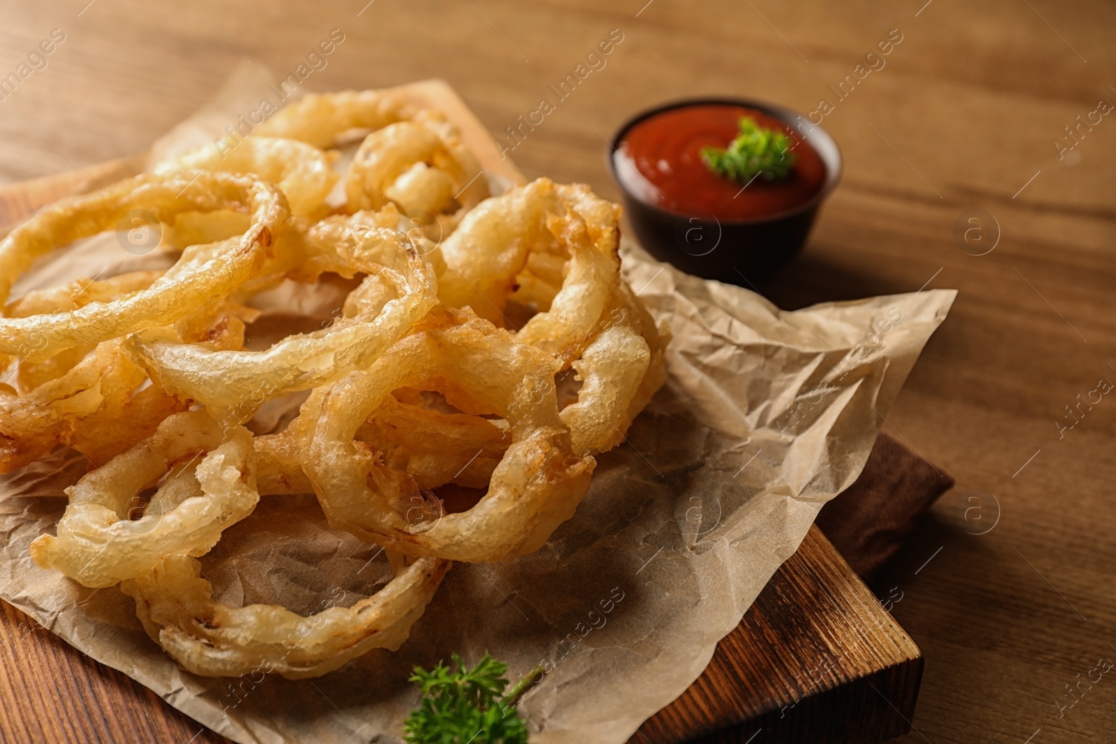 Photo of Homemade delicious golden breaded and deep fried crispy onion rings on wooden background