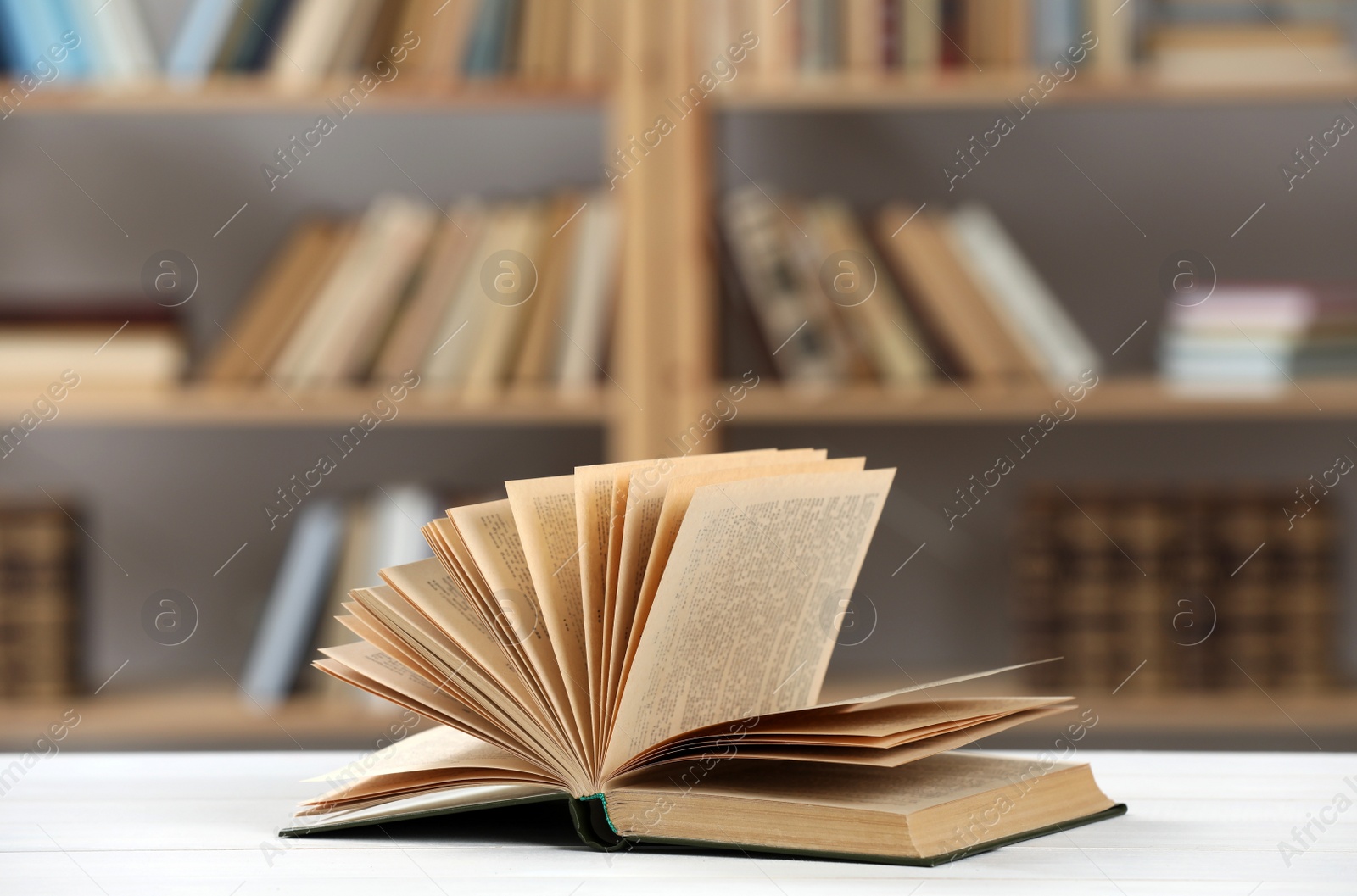 Photo of Open book on white table in library
