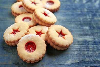 Traditional Christmas Linzer cookies with sweet jam on wooden background