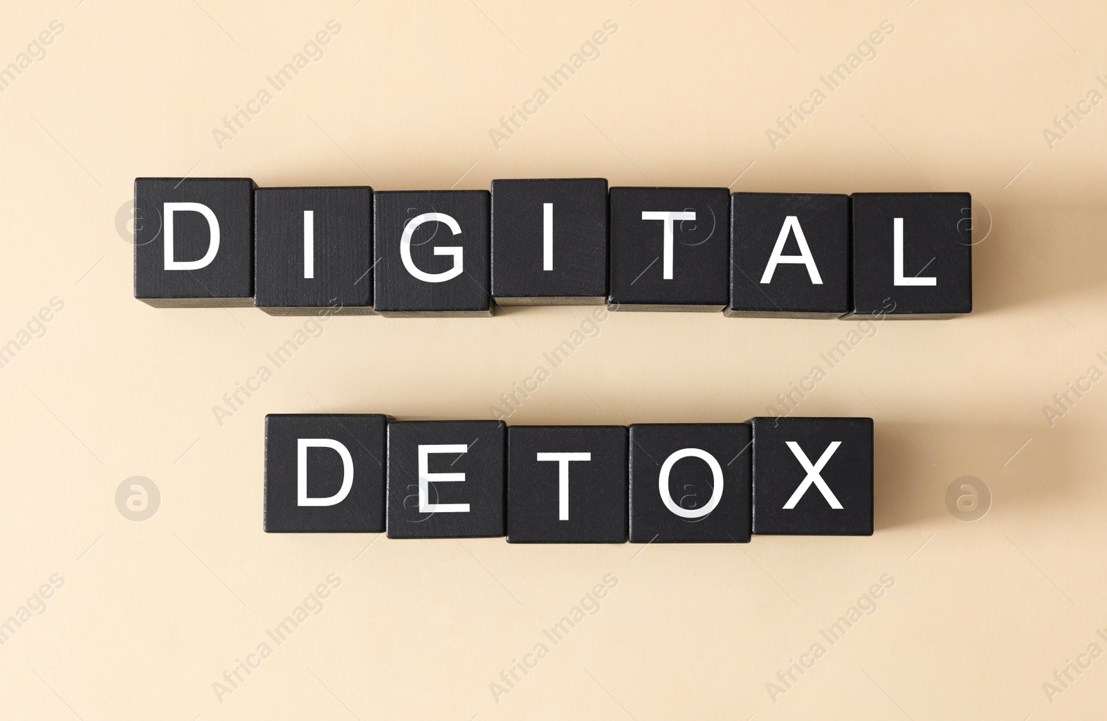 Photo of Black cubes with words DIGITAL DETOX on beige background, flat lay