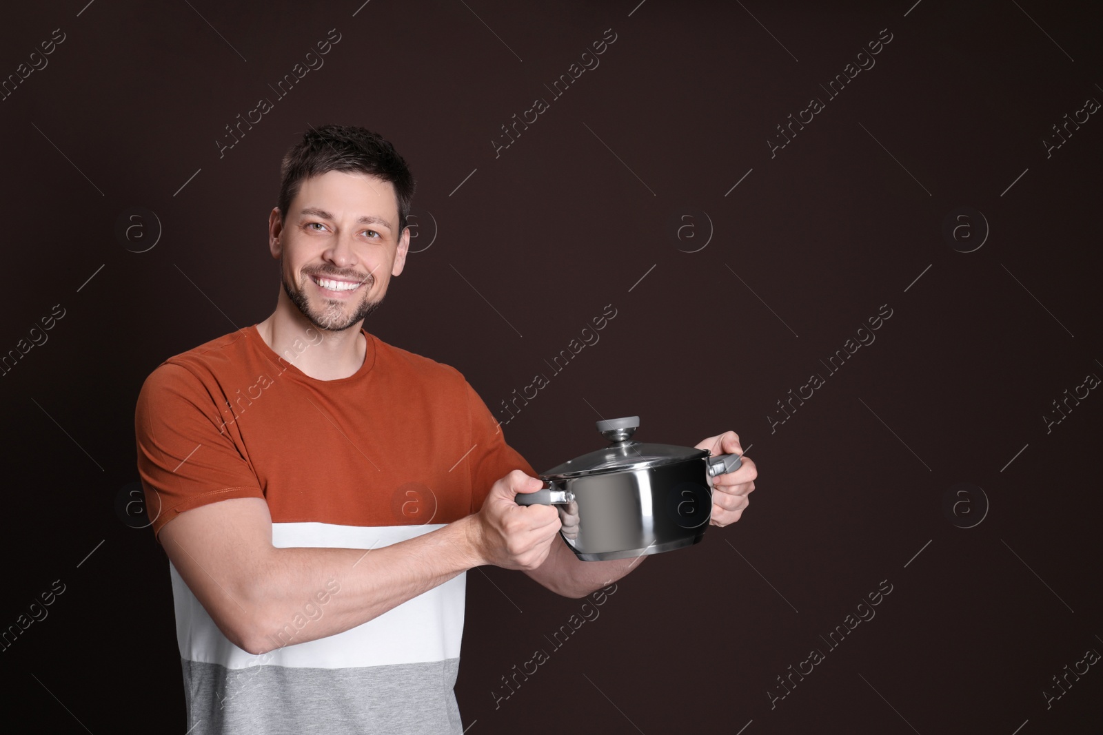 Photo of Happy man with pot on dark background. Space for text