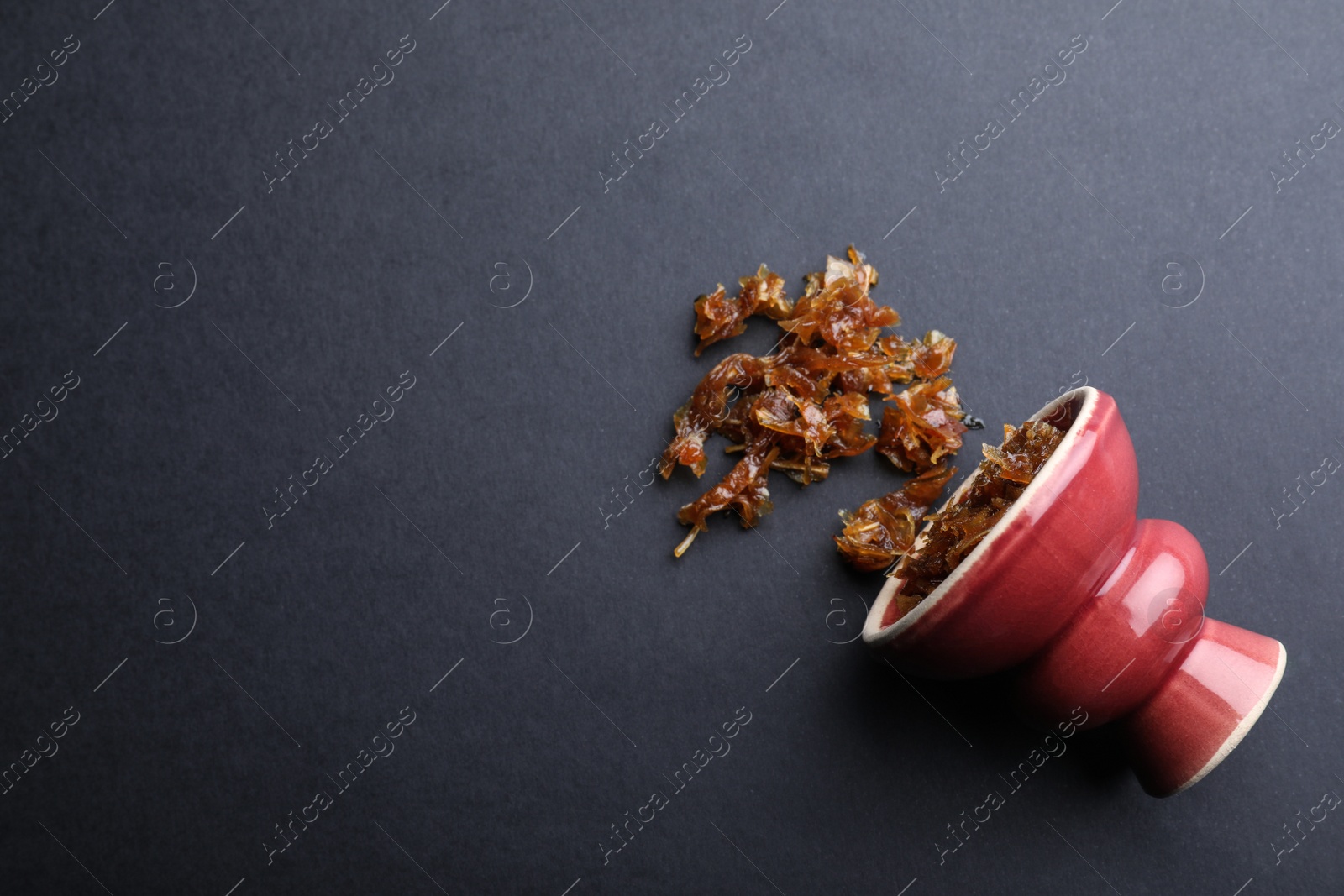 Photo of Modern hookah bowl with tobacco on black background, flat lay. Space for text