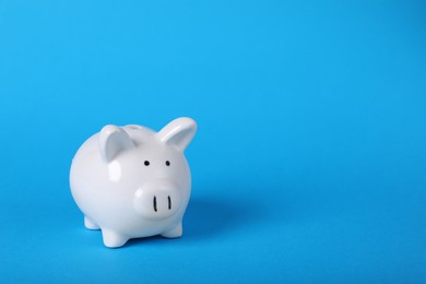 Photo of Ceramic piggy bank on light blue background, space for text. Financial savings