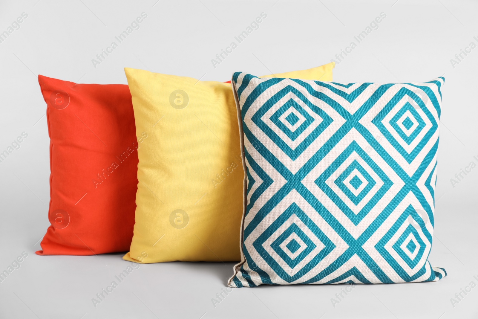 Photo of Different stylish soft pillows on grey background