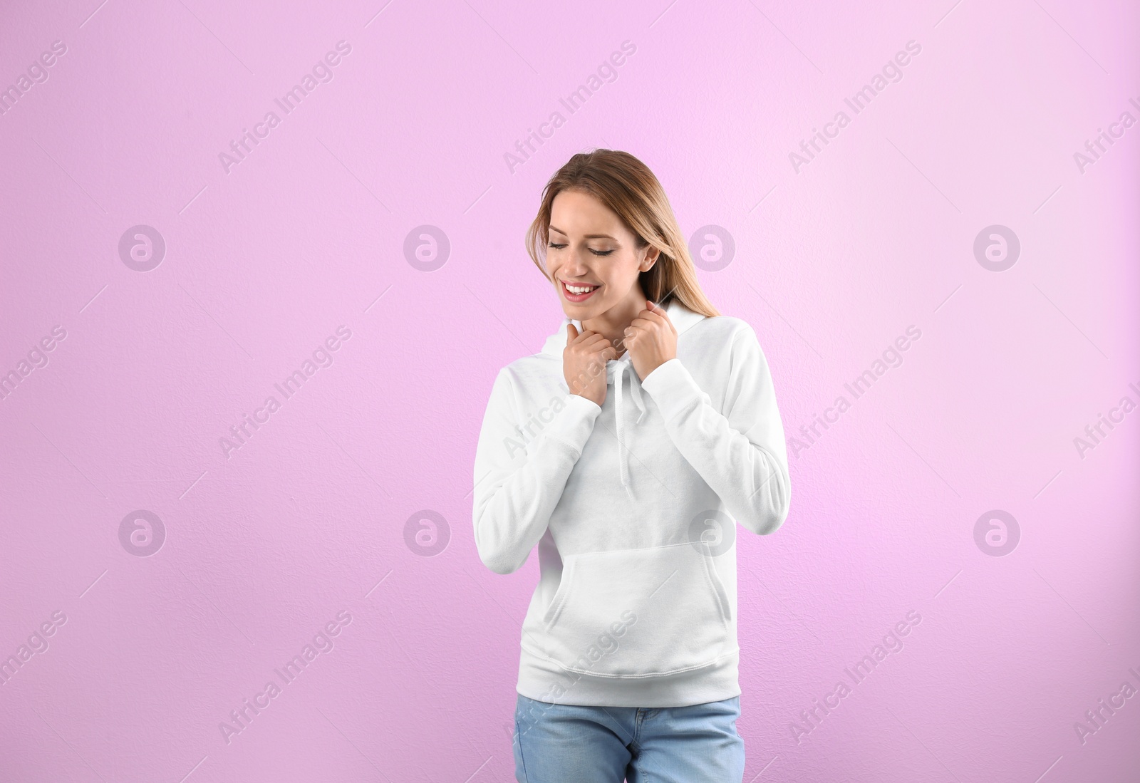 Photo of Portrait of woman in hoodie sweater on color background. Space for design