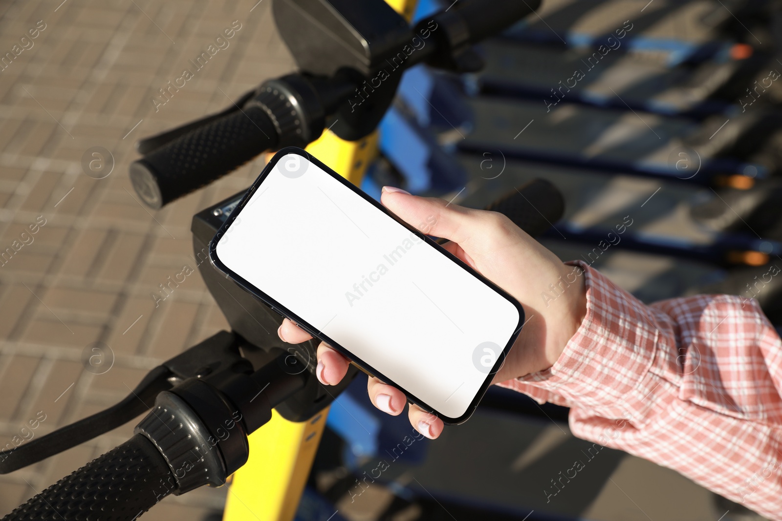 Photo of Woman using smartphone to pay and unblock electric kick scooter outdoors, closeup