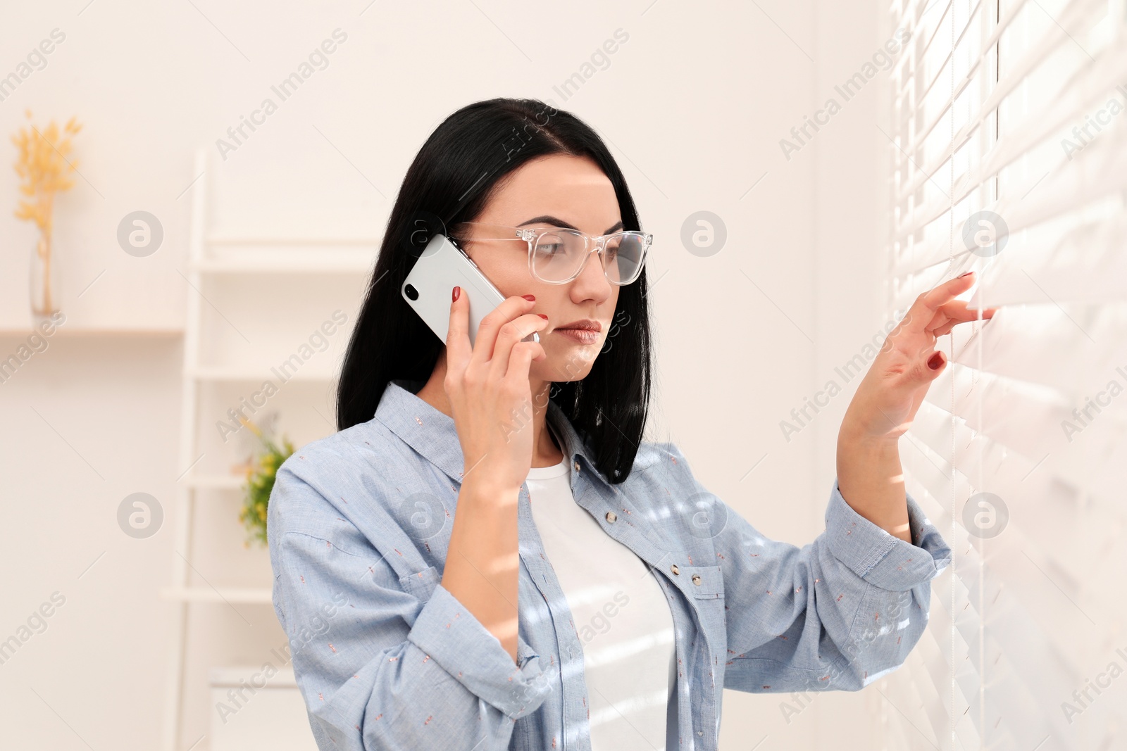 Photo of Beautiful young woman talking on phone indoors