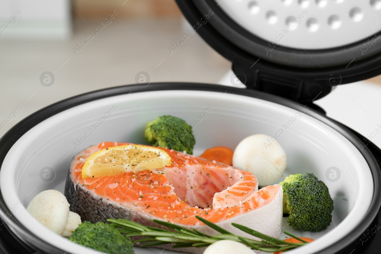 Photo of Salmon steak with garnish in multi cooker, closeup