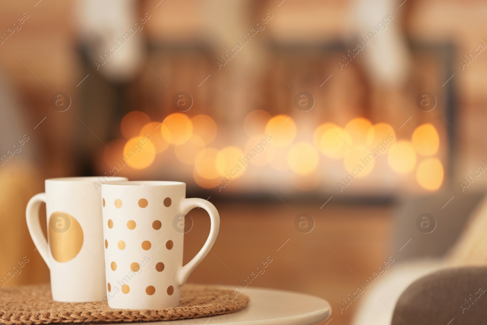 Photo of Cups on white table in decorated living room. Christmas interior