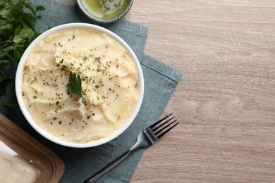 Photo of Delicious mashed potato with parsley served on wooden table, flat lay. Space for text