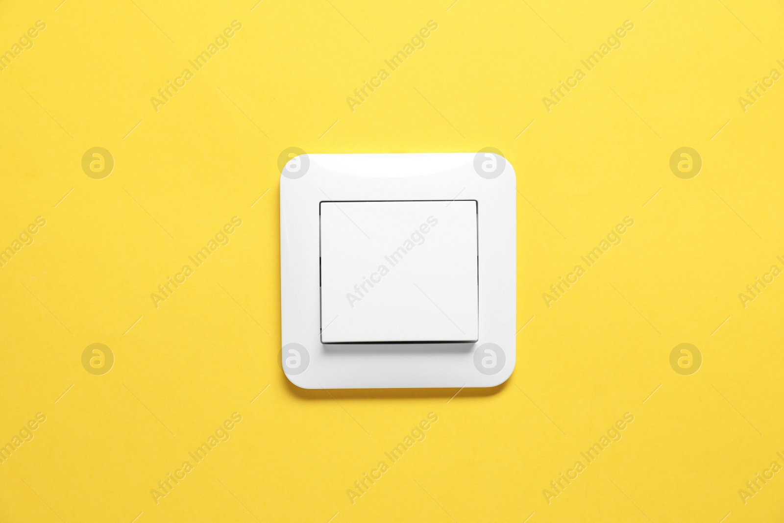 Photo of Modern plastic light switch on orange background