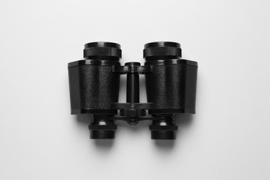 Photo of Modern binoculars on white background, top view