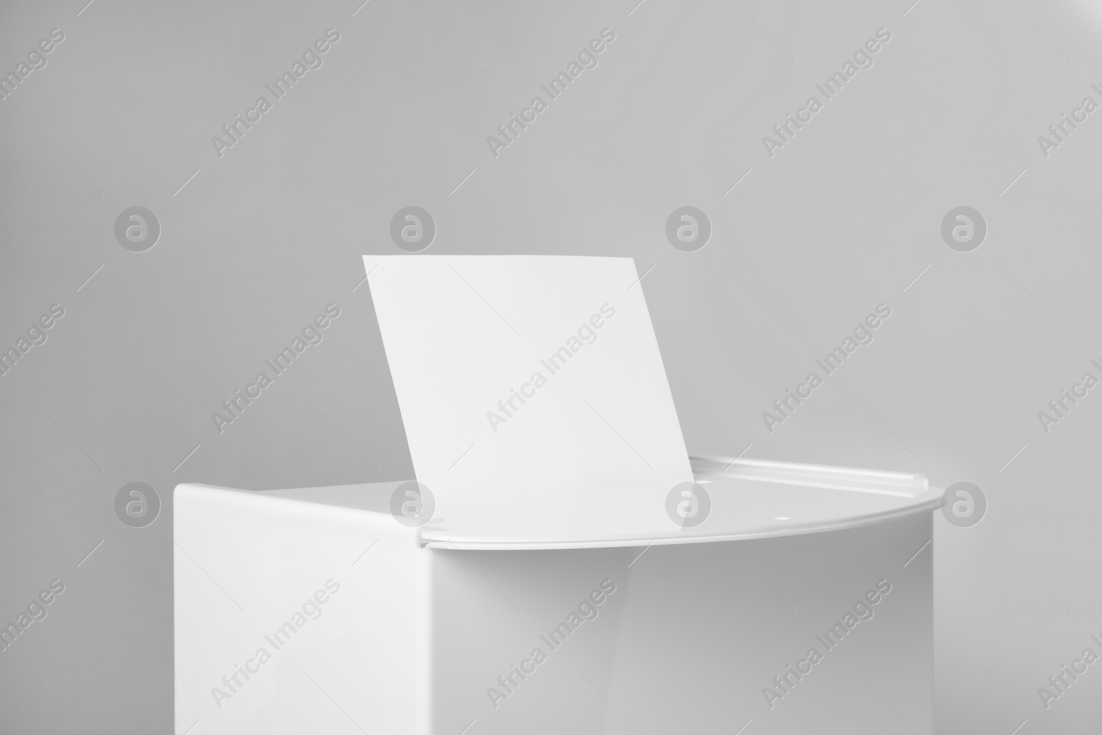 Photo of Ballot box with vote on light grey background, closeup. Election time