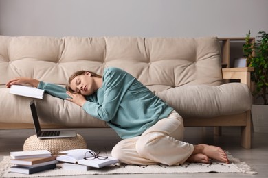 Young tired woman sleeping near couch at home