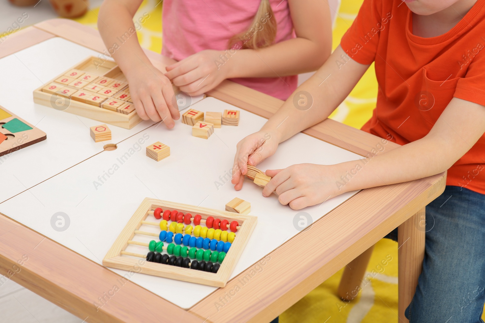 Photo of Children playing with different math game kits at desk indoors, closeup. Study mathematics with pleasure