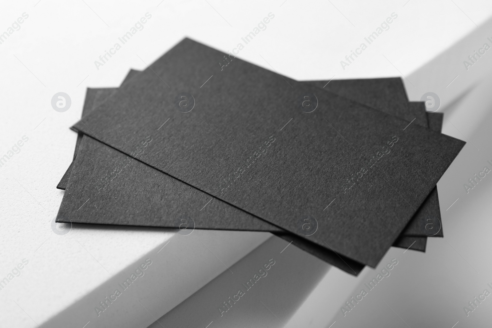 Photo of Blank black business cards on light background, closeup. Mockup for design