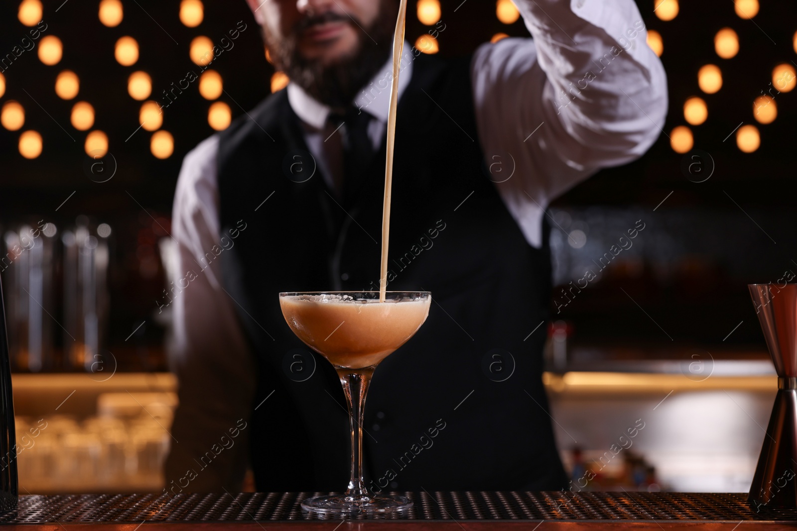 Photo of Bartender preparing Espresso Martini at bar counter, closeup. Alcohol cocktail