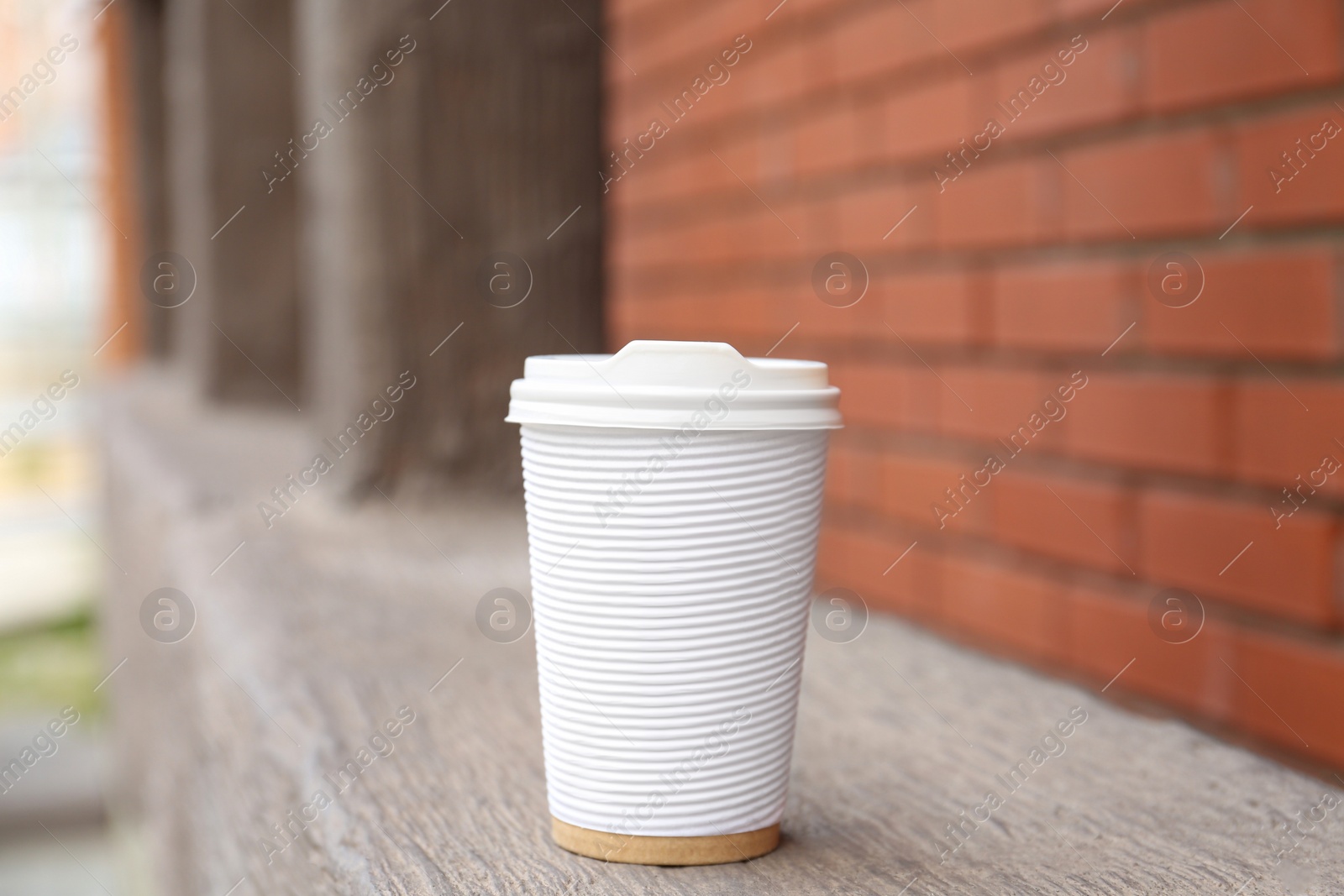 Photo of Paper cup of coffee outdoors. Takeaway drink