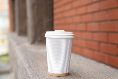Photo of Paper cup of coffee outdoors. Takeaway drink