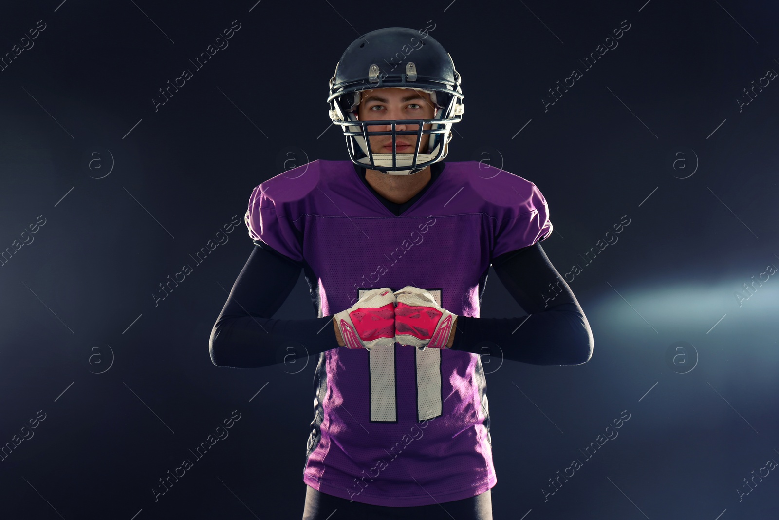 Photo of American football player in uniform on dark background