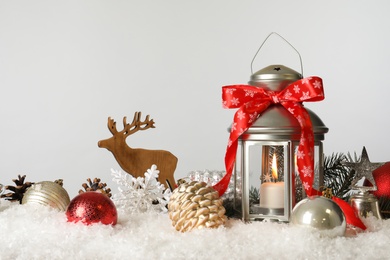 Photo of Beautiful composition with vintage Christmas lantern and festive decorations on snow against white background