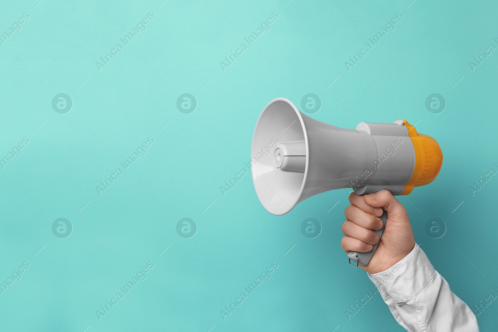 Photo of Man holding megaphone on color background