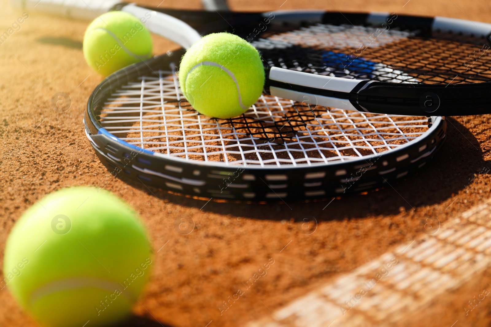 Photo of Tennis balls and rackets on clay court, closeup