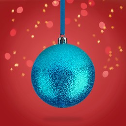 Image of Beautiful blue Christmas ball hanging on red background