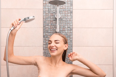 Photo of Beautiful young woman taking shower at home