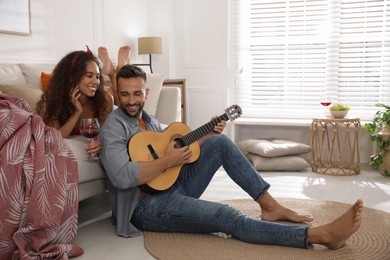 Lovely couple with guitar spending time together at home