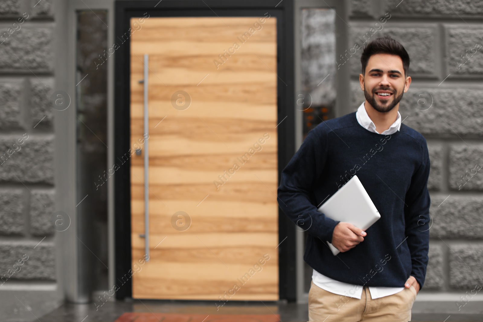 Photo of Young male business owner with tablet near his cafe. Space for text