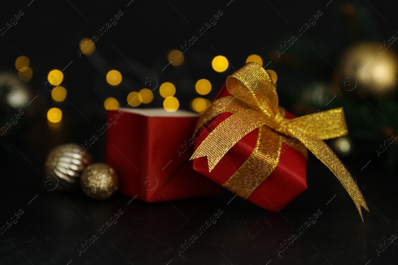 Photo of Red gift box with Christmas balls on wooden table