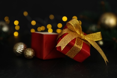 Photo of Red gift box with Christmas balls on wooden table