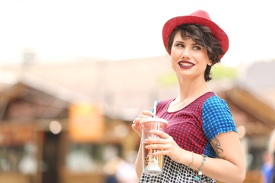 Photo of Young woman with cup of tasty lemonade outdoors