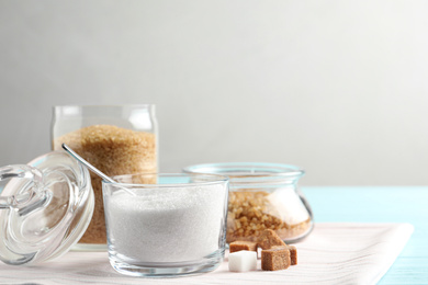 Various bowls with sugar on light blue wooden table