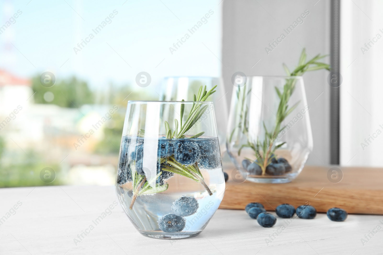 Photo of Refreshing blueberry cocktail with rosemary on table