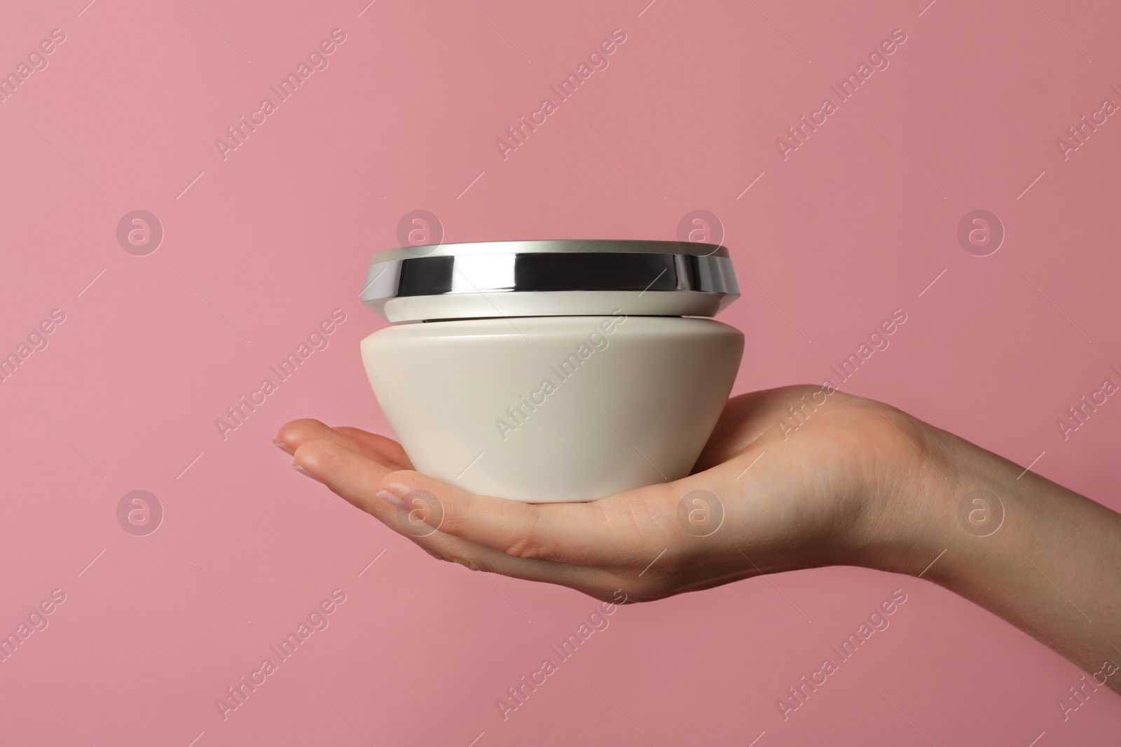 Photo of Woman holding jar of hair care cosmetic product on pink background, closeup