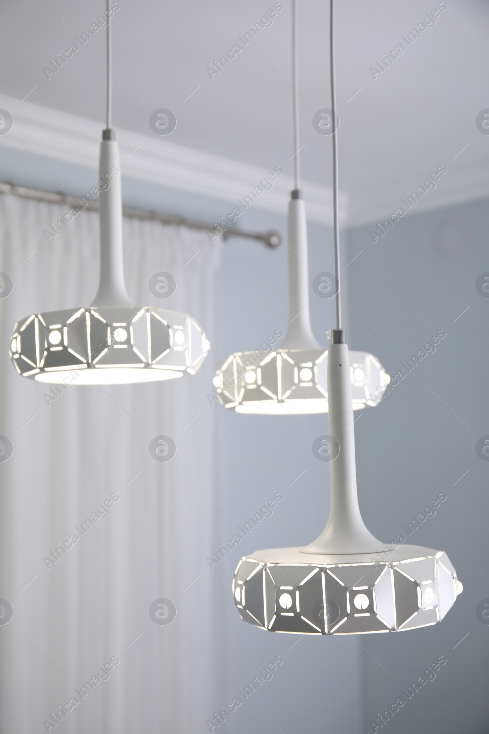 Photo of Stylish pendant lamp on white ceiling indoors