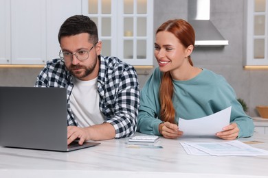 Couple using laptop for paying taxes at home