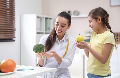 Photo of Little girl visiting professional nutritionist in office