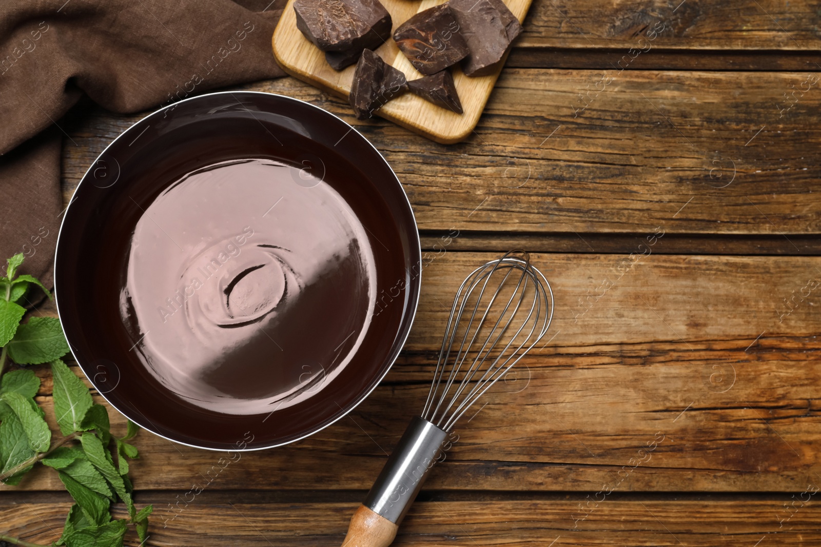 Photo of Delicious chocolate cream, whisk and mint on wooden table, flat lay. Space for text