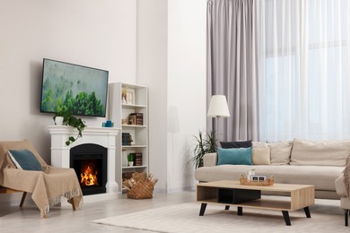 Stylish living room interior with cozy sofa, table, TV set and fireplace