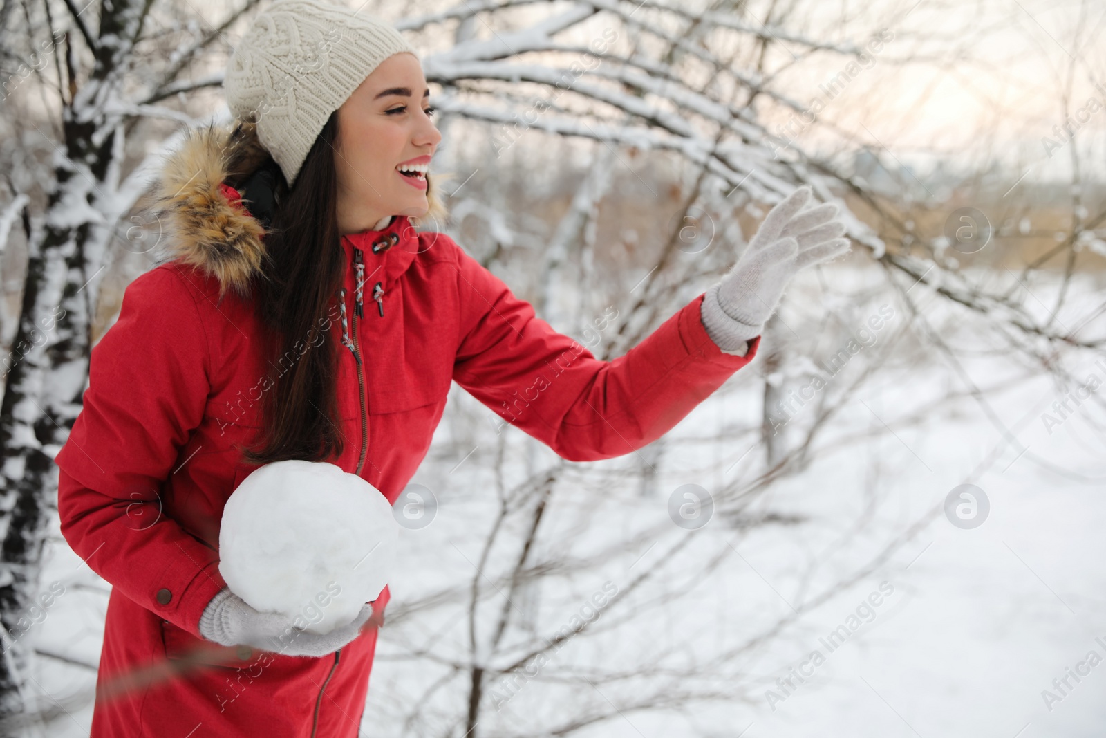 Photo of Young woman holding snowball outdoors on winter day. Space for text