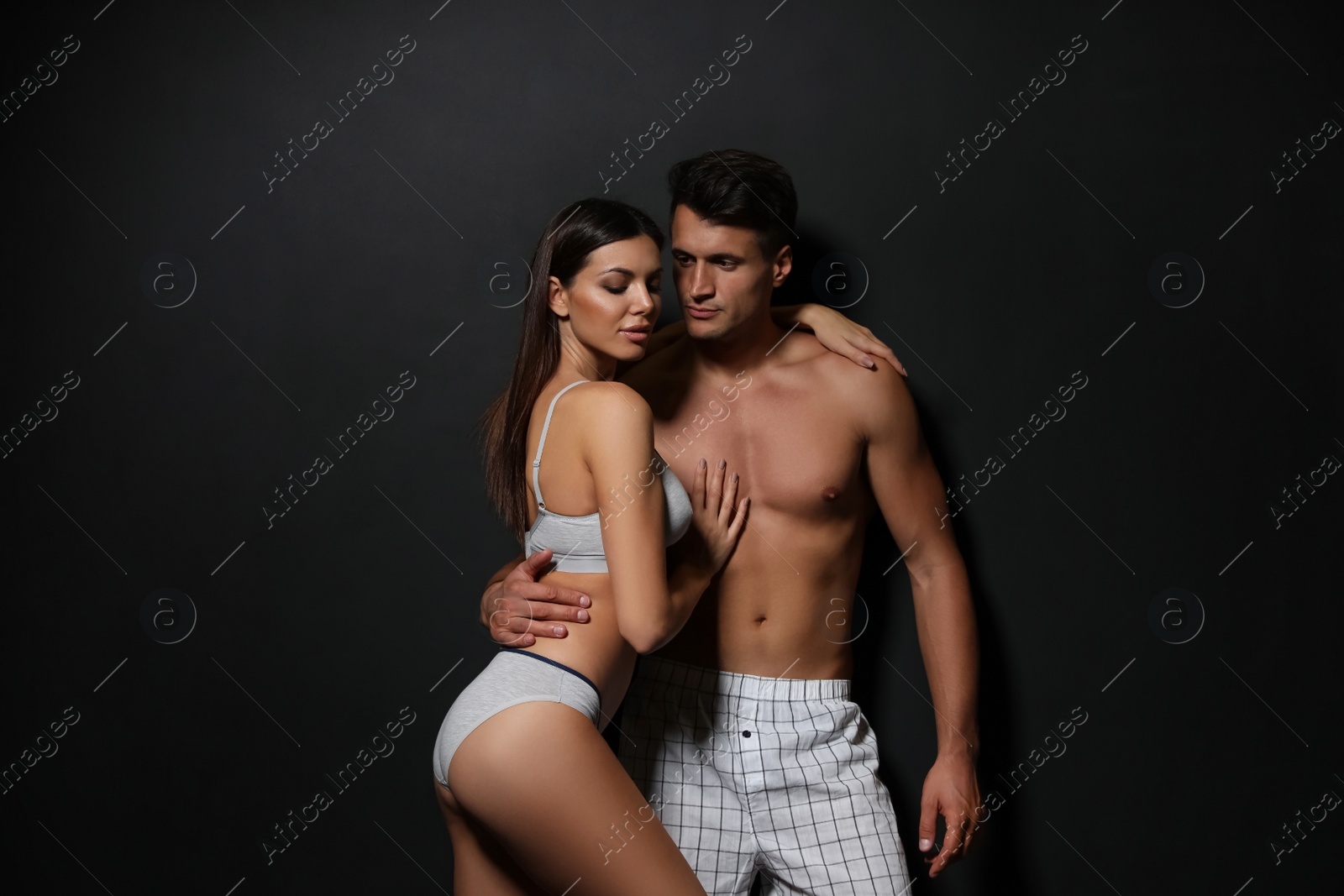 Image of Young couple wearing underwear on black background 