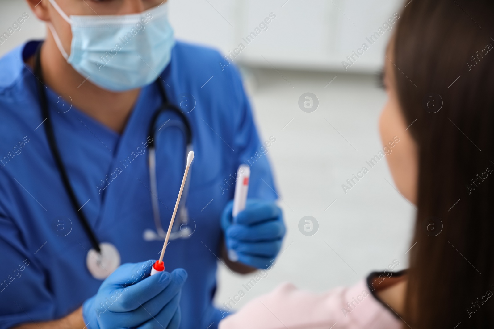 Photo of Doctor taking sample for DNA test from woman in clinic